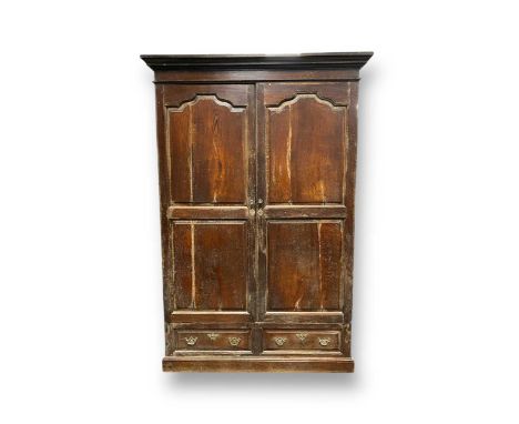 An 18th century oak cupboard, the fielded arched panelled doors enclosing a single shelf with hanging hooks, over two dummy d