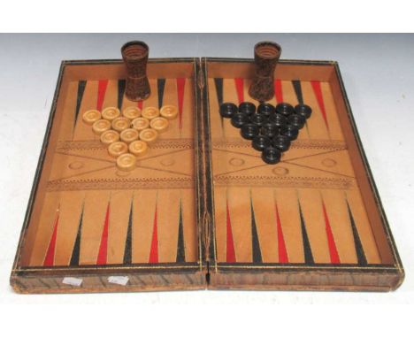 Backgammon set in leather bound book form, the playing surface in red black and gilt, with turned wood pieces and faux tortoi