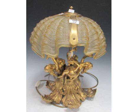 A table lamp comprised of gilt metal nereids or nymphs with acanthus tails supporting a giant clam form moulded shade, overal