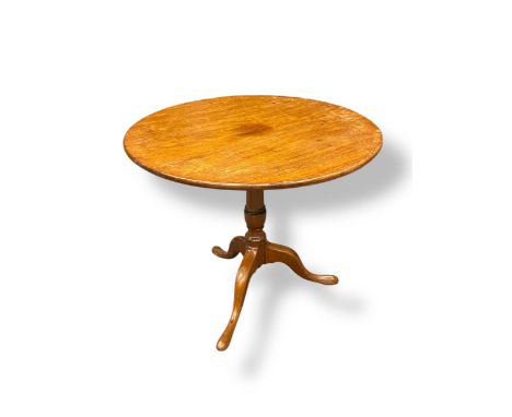 A George III oak tripod table, the circular tilt-top over a turned column support on pad feet, 71 x 85cm
