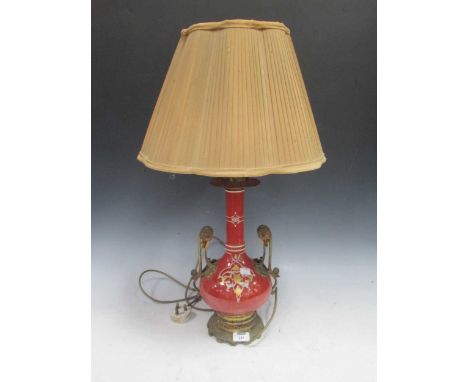 A late Victorian or Edwardian lamp with red ceramic body, two cast gilt metal handles and conforming base (adapted, untested)