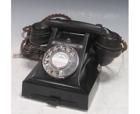 An early 20th century black bakelite telephone,with rotary dial and call exchange feature, pull out drawer.15cm high