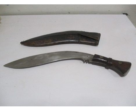 A Kukri knife, the blade stamped C I, G,1916 and 43, in leather scabbard