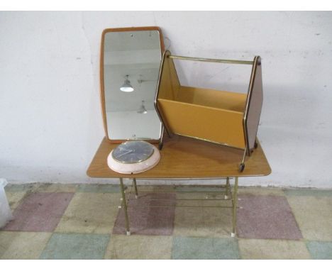 A collection of mid-century furniture including a small coffee table, magazine rack, hanging mirror and clock.