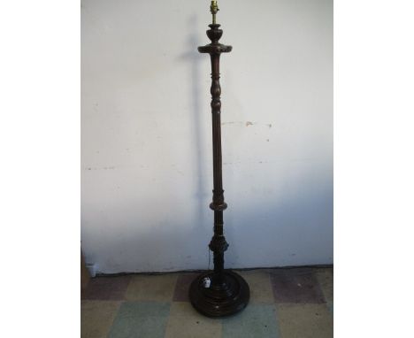 A carved wooden standard lamp