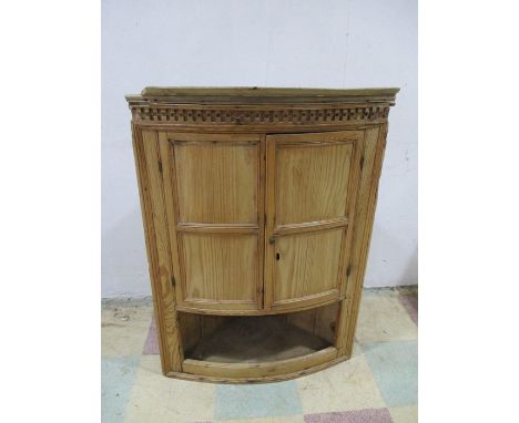 A pine hanging two door corner cupboard with shelf under