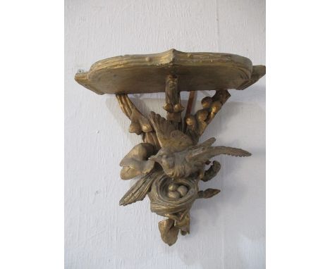 A carved gilded wall bracket decorated with a bird in its nest, height approx. 22cm