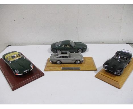 A collection of four model cars including Maisto Aston Martin DB7 Premiere edition 1/18, Burago Jaguar E type 1961 1/18, a Da