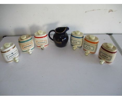 A collection of Wade ceramic sprit barrels, along with a Grant's Scotch Whisky water jug