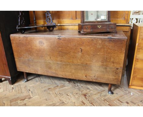 A Georgian oak flap leaf gate leg table with long plank top on club feet, approx length 137cm x height 70cm x width 47cm when
