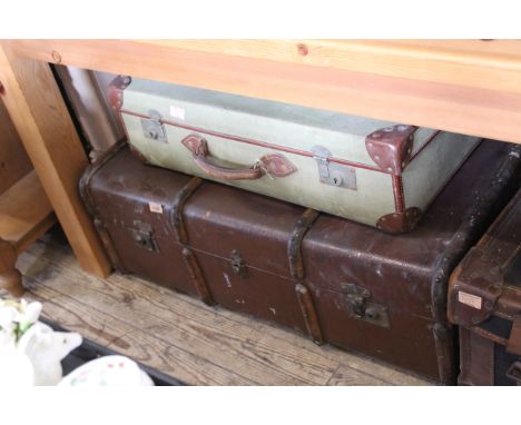 A vintage steamer trunk and a canvas suitcase