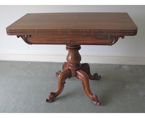 A William IV rosewood card table,  with swivel fold over top, revealing a green circular baize, upon a turned bulbous column,