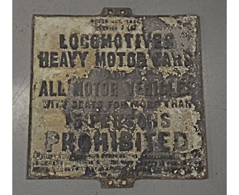 A vintage cast iron road sign, rectangular and stating 'Locomotives, Heavy Motor Cars and all Motor Vehicles with seats for m