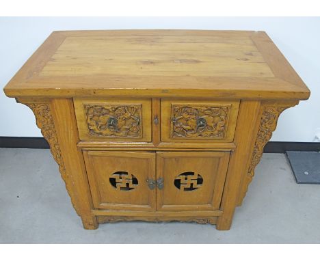 A contemporary Asian/Chinese blonde hardwood sideboard, rectangular top above two frieze drawers and a pair of panelled doors