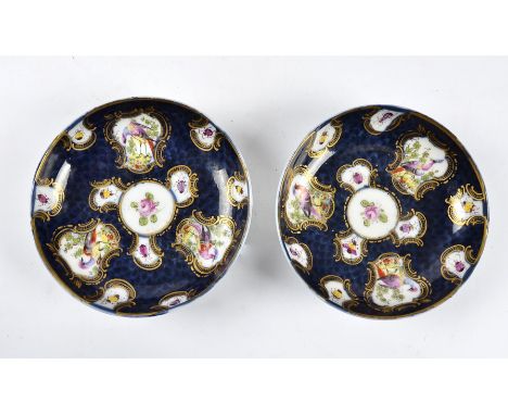 A pair of hand decorated 18th Century Worcester saucers,  with cartouches of birds and insects on ground scale blue, highligh