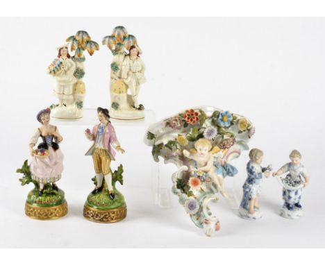 Six continental porcelain figures and a wall bracket,  including a pair of male and female figures holding flowers, with unde