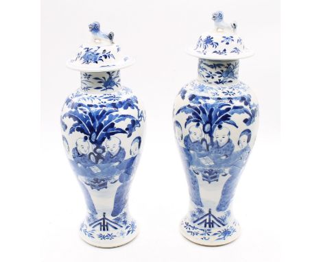 A pair of Chinese blue and white porcelain baluster vases and covers, painted with maidens and boys, the covers with Fo Dog f