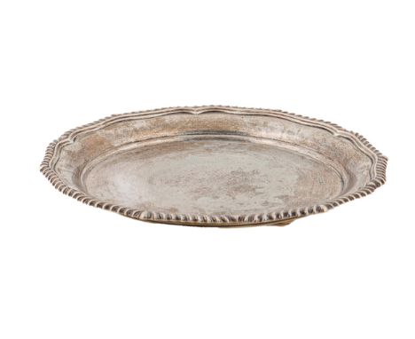 An Edwardian silver salver, with engraved centre and shaped, gadrooned rim, on three feet, 26cm diam, by James Deakin &amp; S