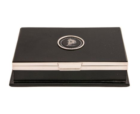 A George V silver mounted ebony cigarette box, the lid inset with a Wedgwood black jasper medallion, 16cm l, by George Betjem