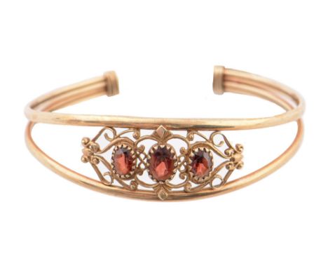 A garnet bangle, in 9ct gold, 60mm (internal), marks obscured, 11.3g ConditionGood condition
