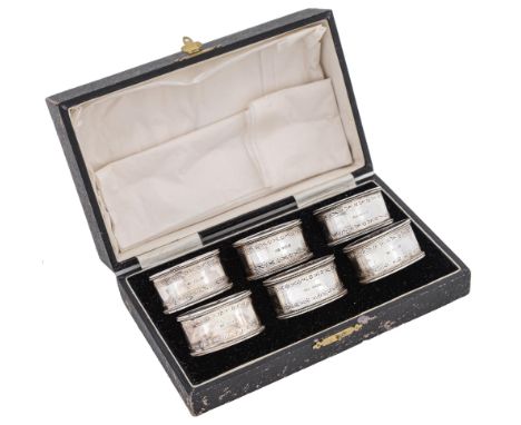 A set of six George V oval silver napkin rings, with engraved borders and beaded rims, by John Rose, Birmingham 1929, 3ozs 15