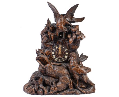 A Swiss limewood cuckoo clock, late 19th c, in the form of a rocky crag surmounted by an eagle swooping on another bird and a