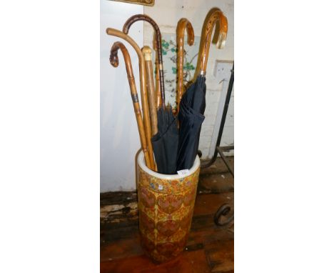 Collection of assorted walking sticks and umbrellas in a modern Chinese porcelain stick stand