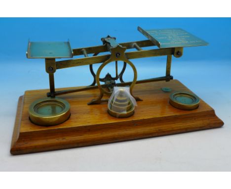 A set of Mordan & Co. postage scales and weights on an oak base