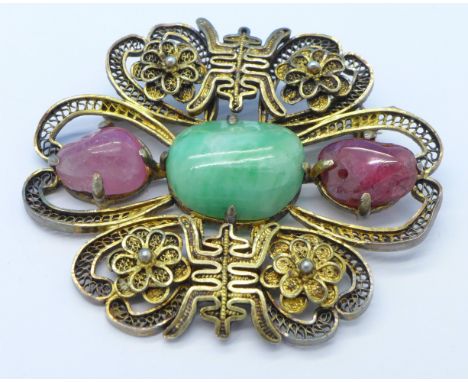 A Chinese jade, ruby and silver gilt brooch, 5cm