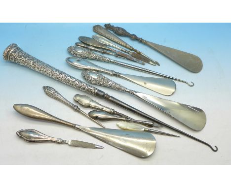 A collection of silver handled button hooks, shoe horns and manicures