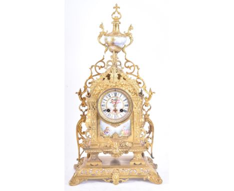 A 19th century French gilt brass and enamel porcelain painted mantel clock. The cylinder head clock inset with Sevres manner 