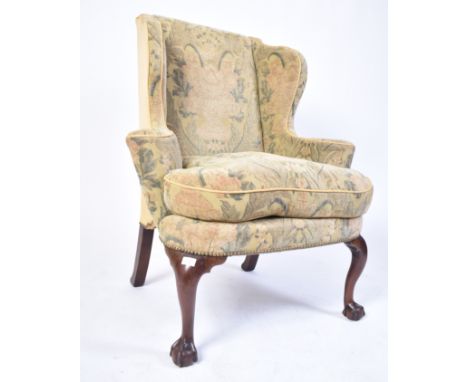A 19th century Queen Anne mahogany wingback armchair. Raised on cabriole legs with claw and ball feet. Scrolled arms and shap