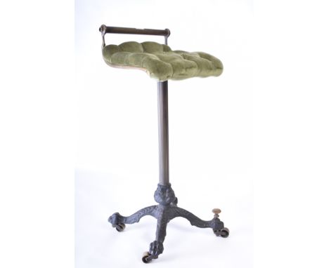 A 19th century brass and cast iron cello stool. The stool having a low bar backrest with green button fabric upholstery suppo