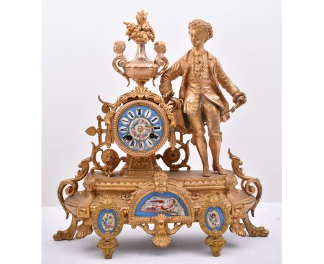 A 19th century French gilt and enamel worked mantel clock. The cylinder head clock inset with Sevres manner porcelain painted