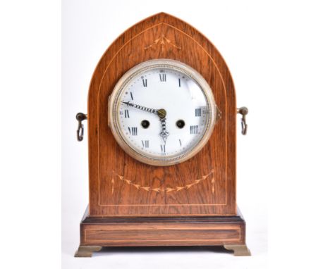 An Edwardian early 20th century mahogany and line inlaid 8-day mantel clock. The clock having a spire shaped inlaid case with