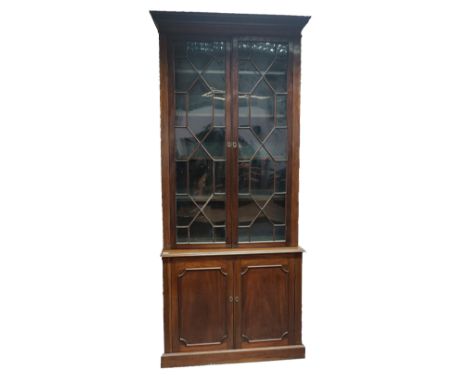 An early 20th century Edwardian mahogany bookcase cabinet in the Chippendale taste. The bookcase having twin astragal glazed 