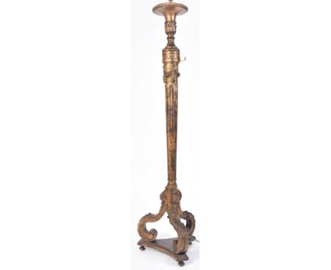 An early 20th century gilt wood tripod standard floor lamp. Gilt reeded tapering body with carved column cup mount set over t