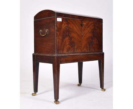 A 19th century George III flame mahogany dome top wine cooler. Raised on inlaid square tapering legs with brass roller castor