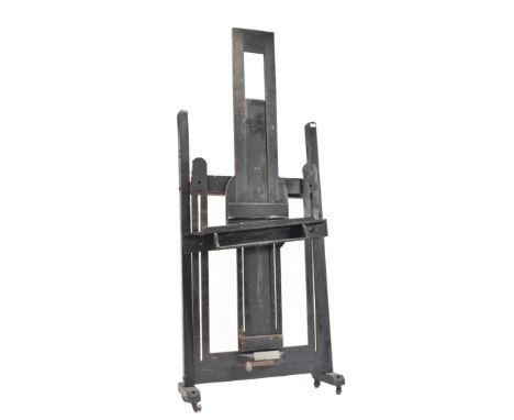 A large Victorian 19th century ebonised painted wood studio artist's easel. The easel raised on brass castors having ebonised