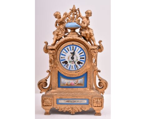 A 19th century French gilt brass and enamel porcelain painted mantel clock. The cylinder head clock inset with Sevres manner 