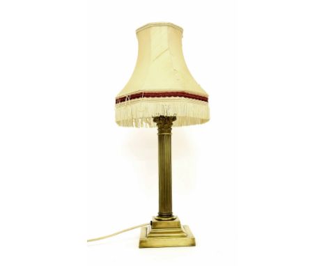 Corinthian style brass table lamp with shade, with a cast capital and reeded column upon a square stepped base, the base 14.5