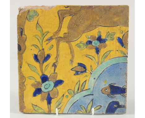 AN 18TH CENTURY PERSIAN SAFAVID YELLOW GLAZED TILE, painted with fish and flora, 23cm square.