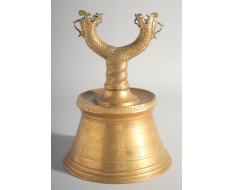 AN ISLAMIC TURKISH BRASS CANDLESTICK, with twin dragon heads, 26.5cm high.