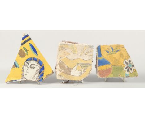 THREE 17TH CENTURY PERSIAN SAFAVID TILE FRAGMENTS, largest 14cm x 15cm.