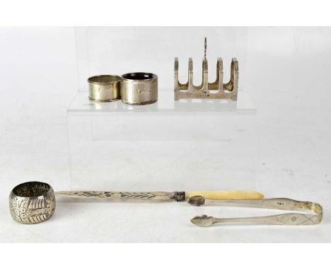 A group of small silver including a simple four-division toast rack, three napkin rings, a pair of sugar nips and a pierced s