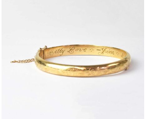A 9ct yellow gold hinged bangle with engraved detail, with further inscription 'Betty Love Jim 2.2.1962', internal width appr