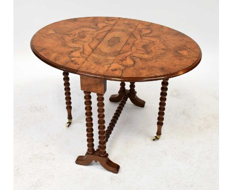 A small Victorian burr walnut gateleg table with ball turned supports and cross stretcher, brass caps and porcelain castors t