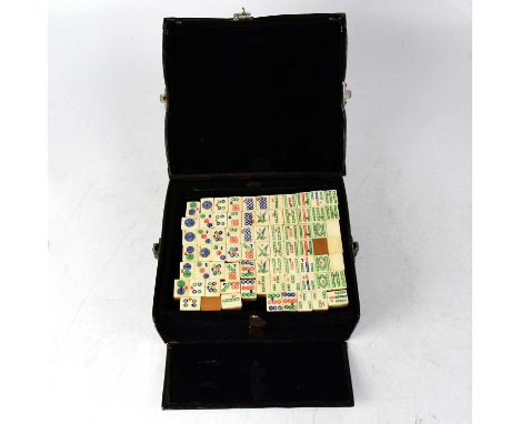 An early 20th century leather cased Mah-Jong set with bone-faced bamboo-backed tiles, each tile approx. 2 x 1.5cm.Condition R