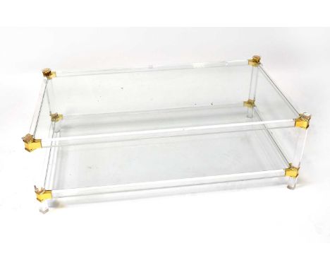 ATTRIBUTED TO PIERRE VANDEL; a Lucite two-tier coffee table with glass shelves and gold-coloured mounts, 41 x 122 x 71.5cm.Co