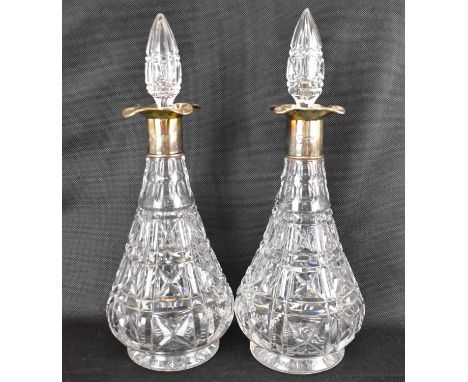 A pair of early 20th century cut and polished glass decanters of club form, with crosses and vertical lens cutting and multi 